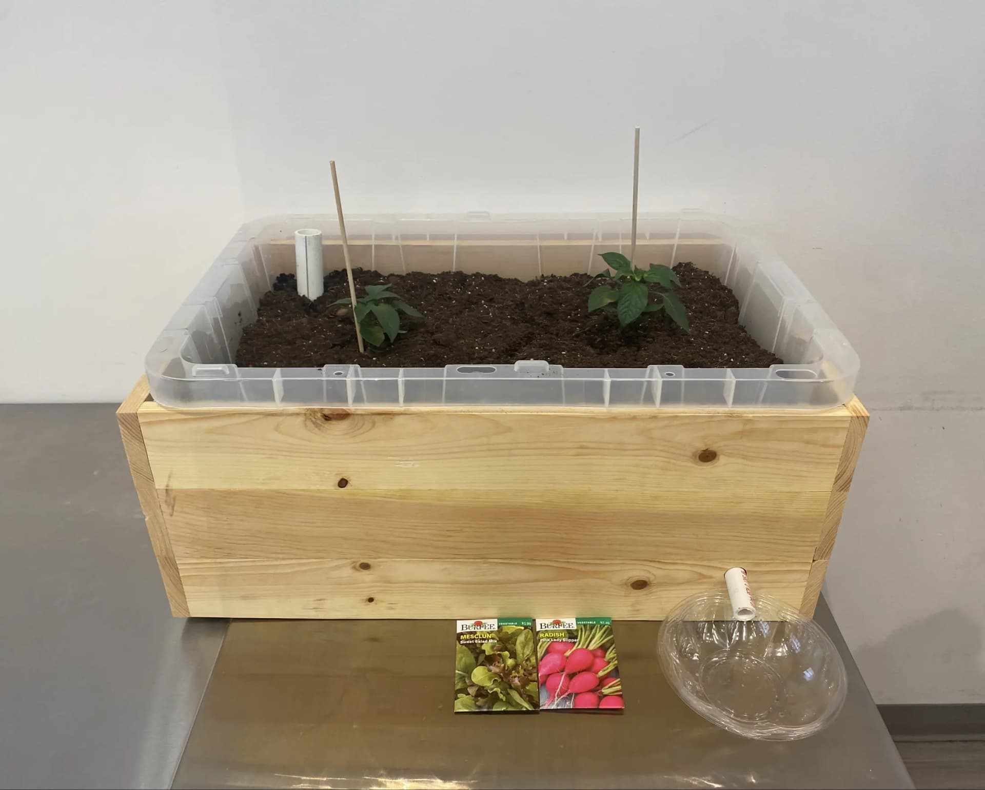 The finished Auto-Watering Planter, a birch planting bed on legs, filled with soil.